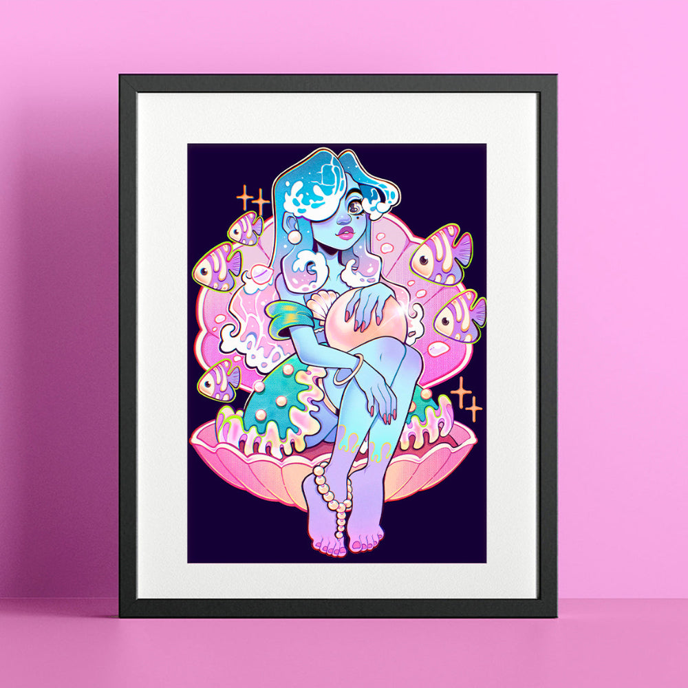 A framed art print featuring a colorful cartoon-style illustration of a woman in a shell with fish, displayed against a pink background.