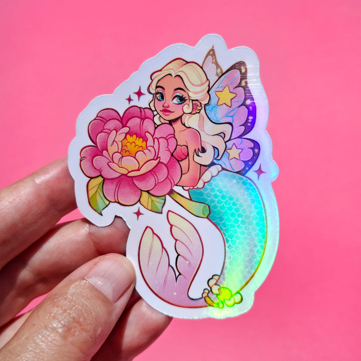 Sticker of a fairy holding a flower against a pink background
