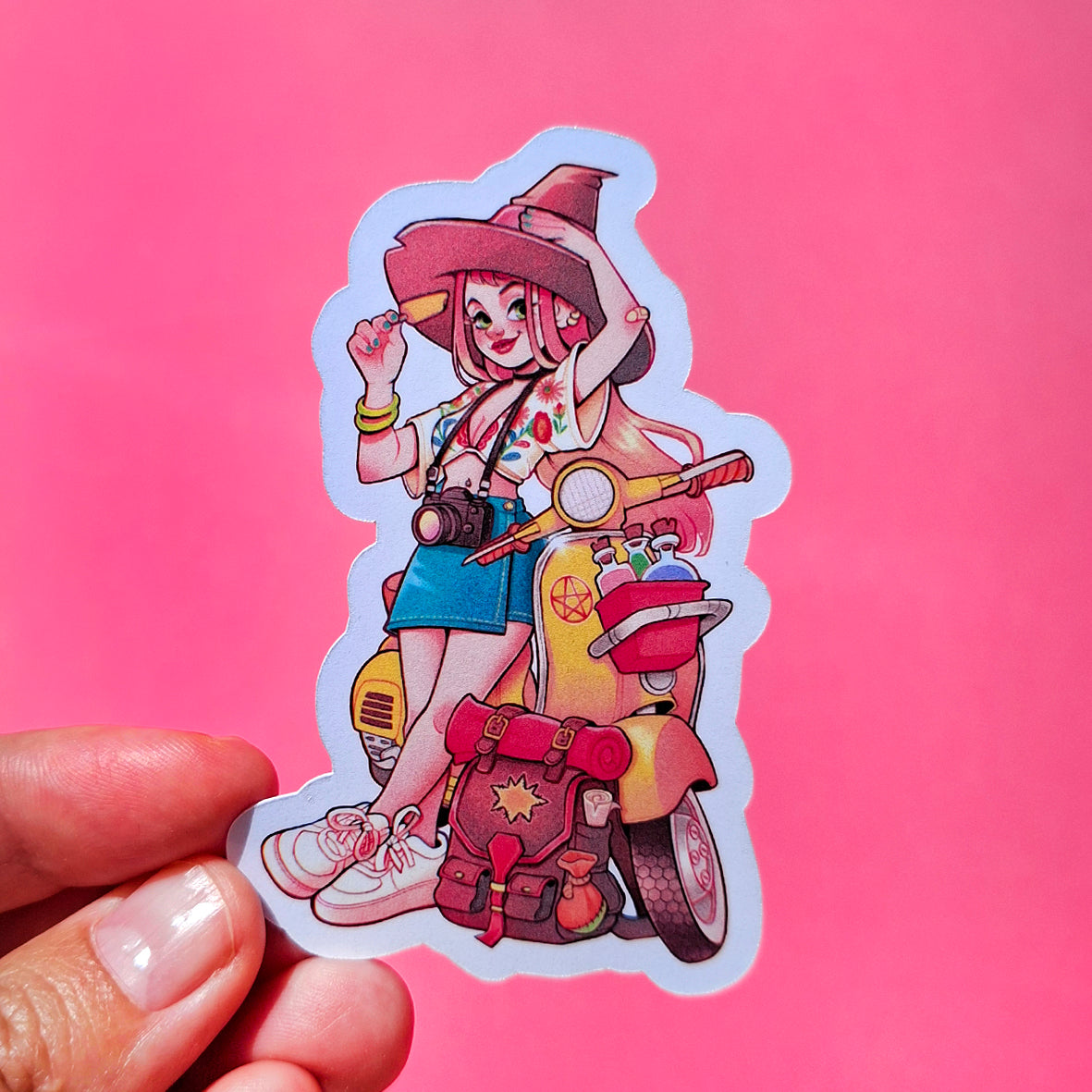 Sticker of an witch character on a pink background